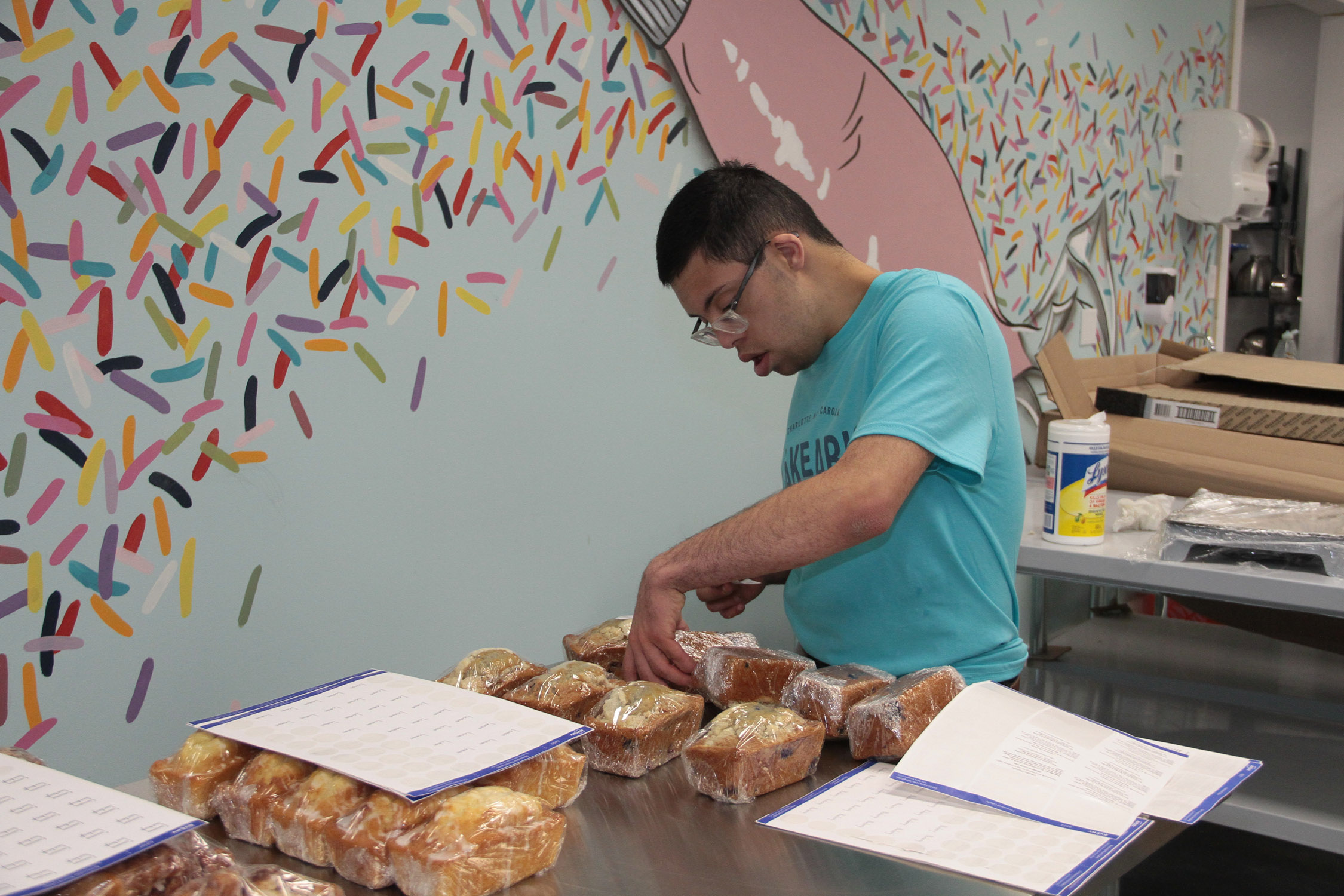 A Cakeable team member arranging wrapped loaves on a work table