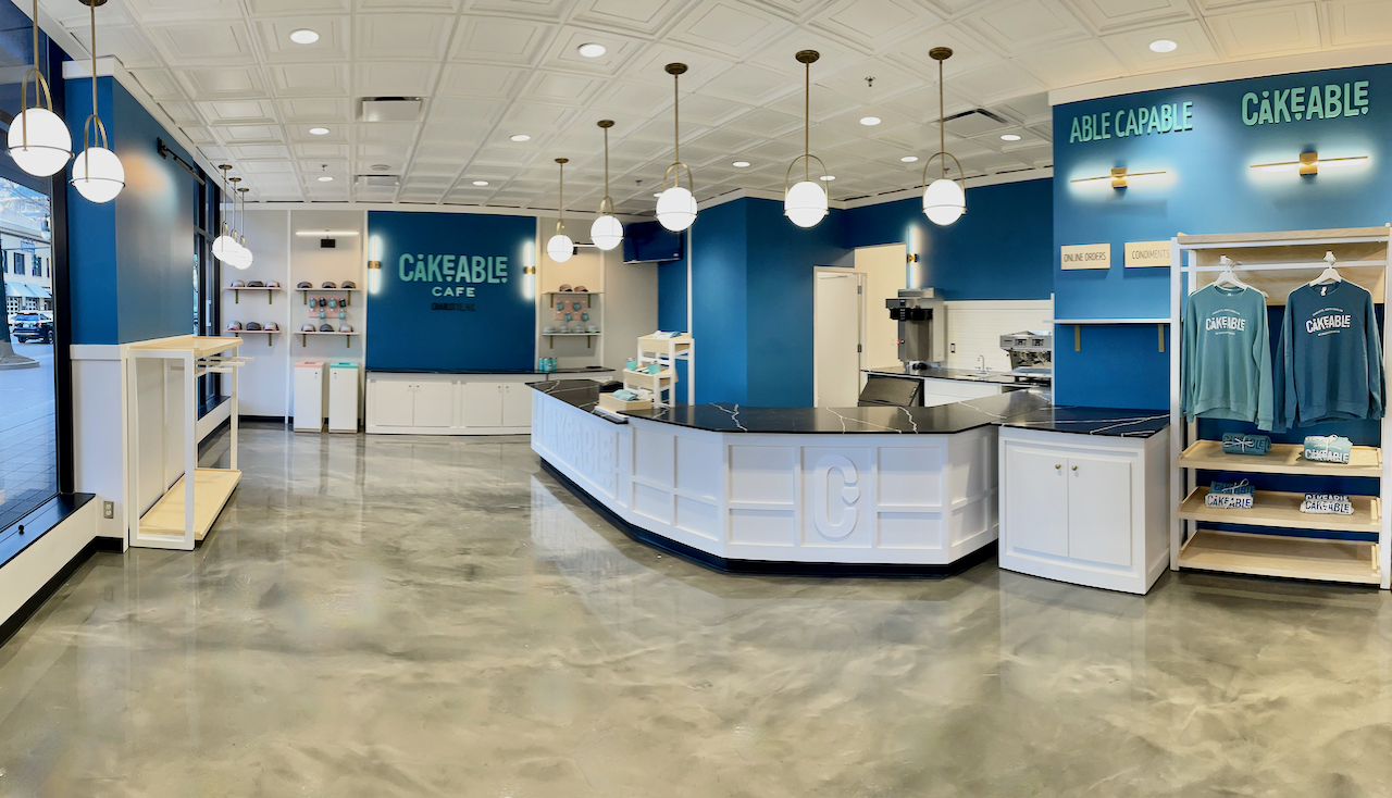The interior of Cakeable Cafe, showing the service counter, pendant lighting and retail shelving